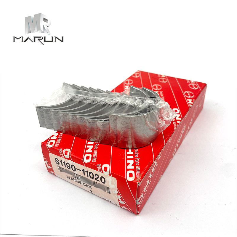 A close-up, 45-degree angle shot of a set of metallic engine bearings wrapped in clear plastic, resting on a red Hino-branded cardboard box with white text.